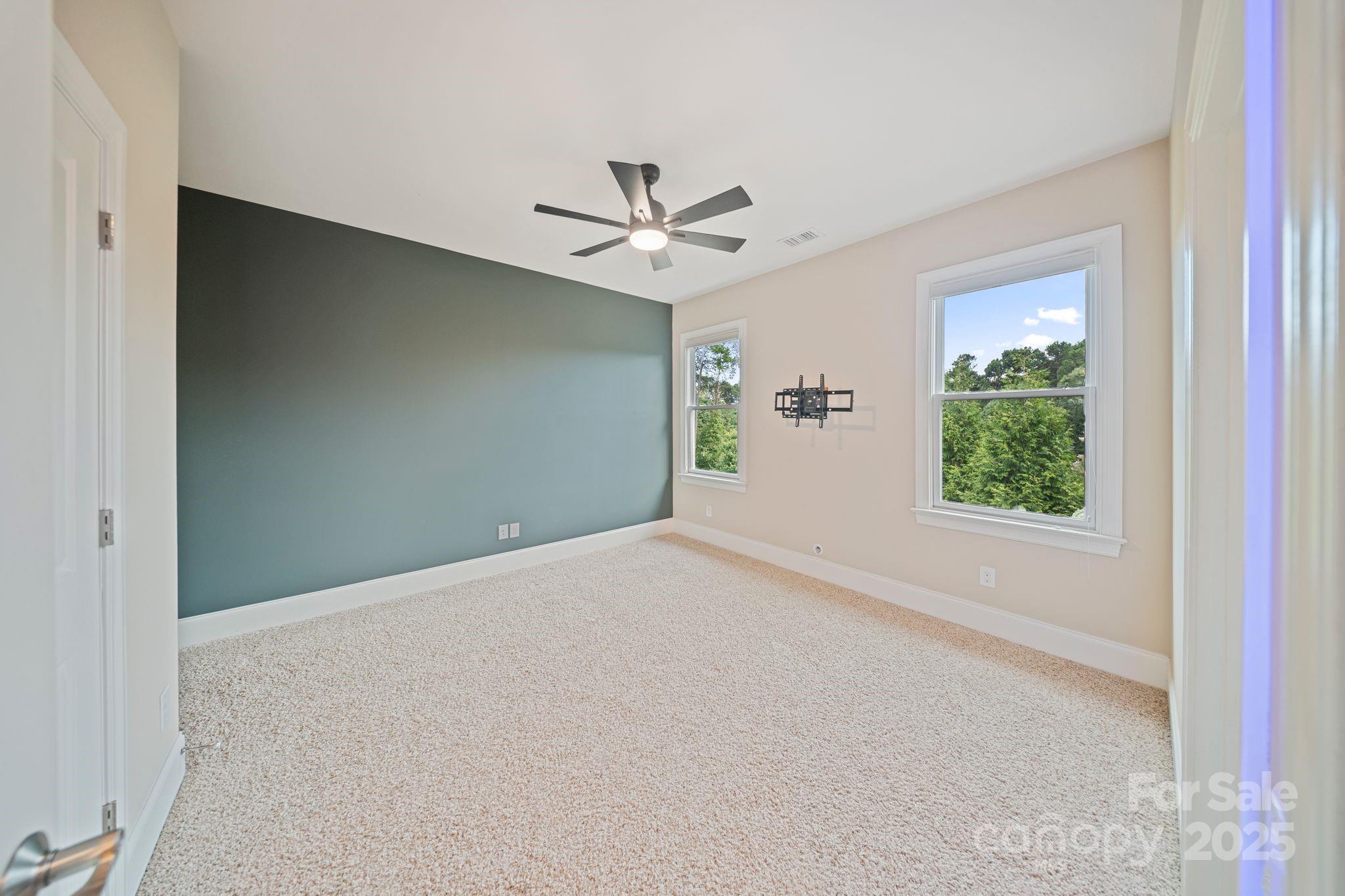2051 Brawley School Road Mooresville, NC 28117 - Photo 31 of 47 an empty room with windows and ceiling fan