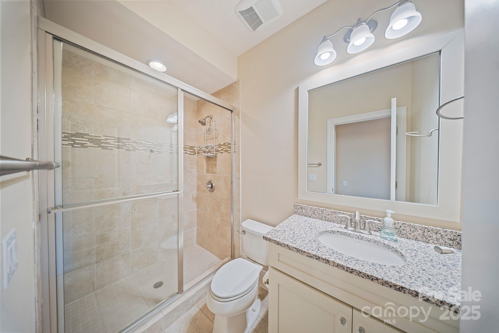 2051 Brawley School Road Mooresville, NC 28117 - Photo 38 of 47 a bathroom with a granite countertop sink toilet and shower glass cabinet