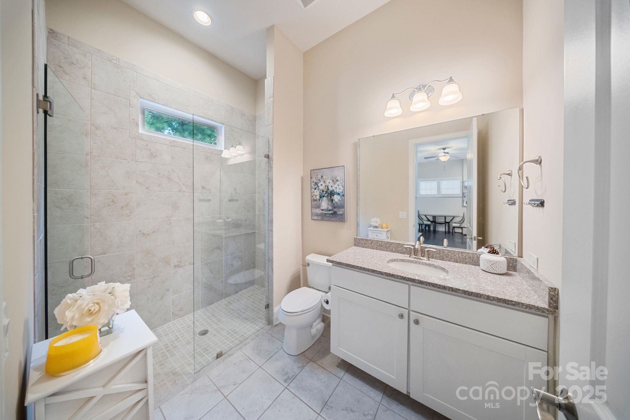 2051 Brawley School Road Mooresville, NC 28117 - Photo 44 of 47 a spacious bathroom with a granite countertop sink a toilet and shower