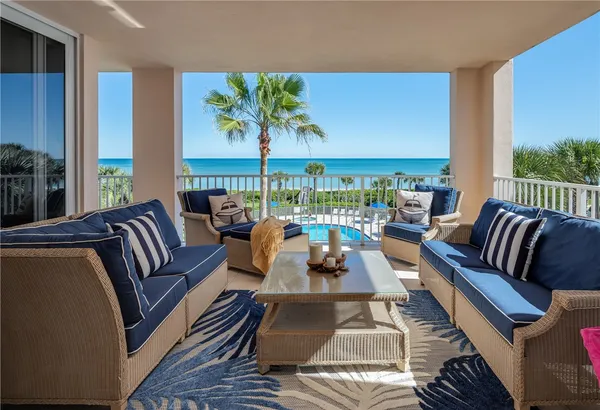 a living room with furniture a rug and a floor to ceiling window