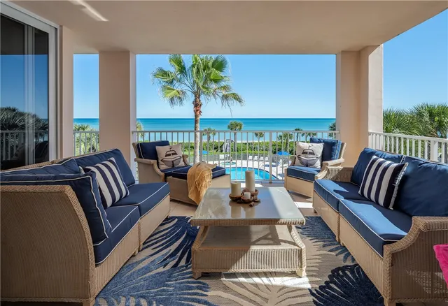 a living room with furniture a rug and a floor to ceiling window