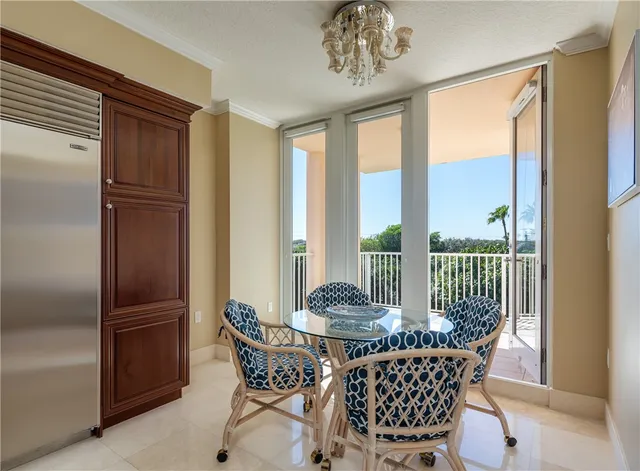 a dining room with furniture large windows and a chandelier