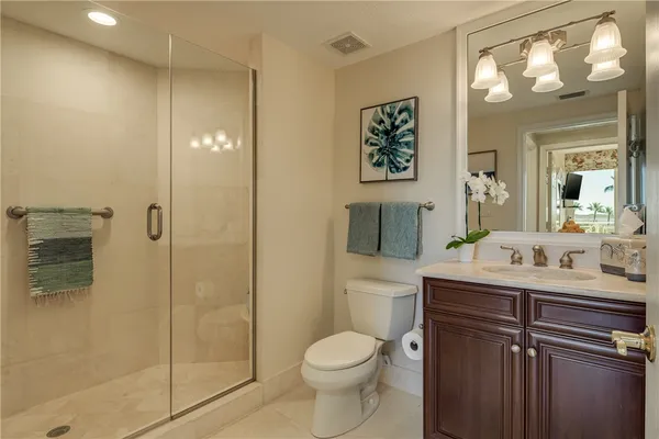 a bathroom with a toilet a sink and glass door