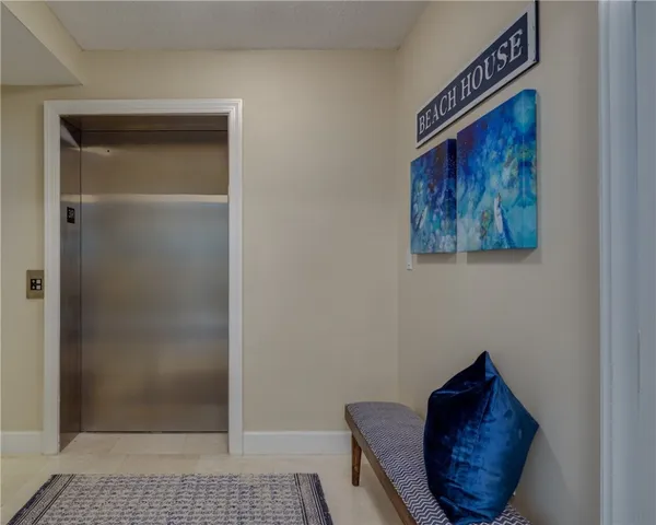 a view of hallway with a chair and a potted plant