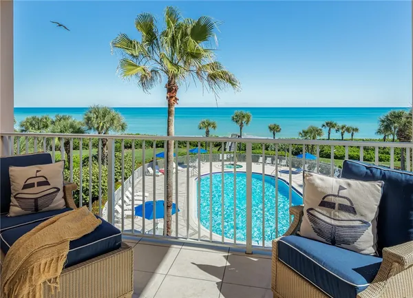a view of a chairs and table in patio with a lake view
