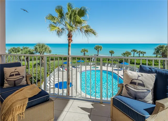a view of a chairs and table in patio with a lake view