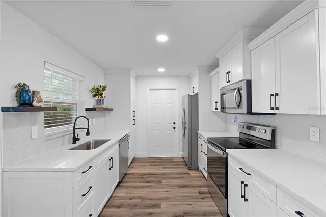 a kitchen with a sink appliances and cabinets