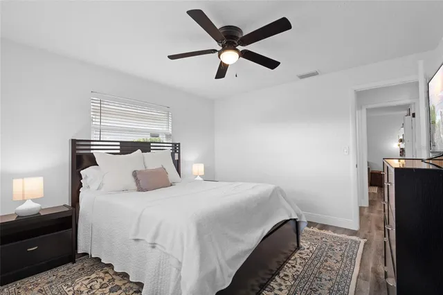a bedroom with a bed and a ceiling fan
