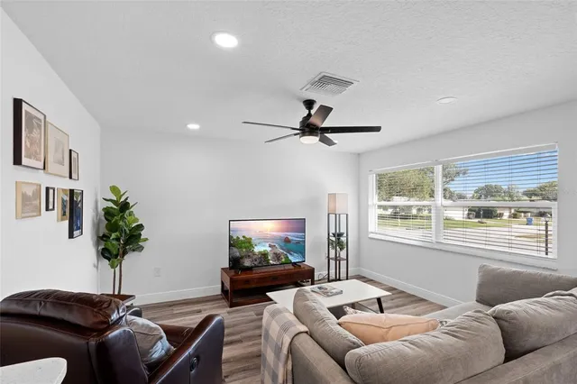a living room with furniture and a wooden floor