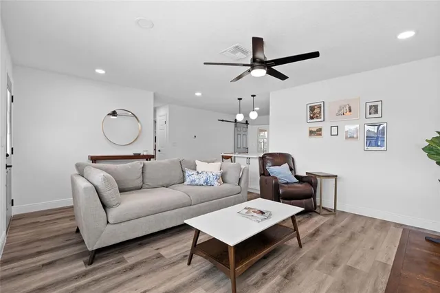 a room with wooden floor furniture and kitchen view