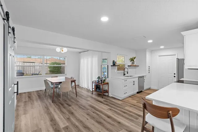 a kitchen with granite countertop a sink and dishwasher a stove top oven with wooden floor