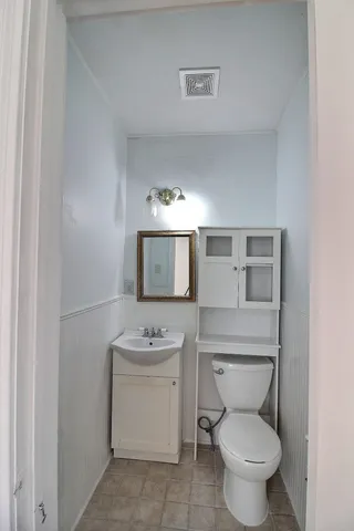 a bathroom with a toilet sink and mirror