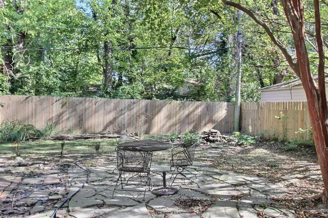 a backyard of a house with table and chairs