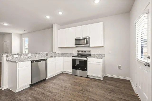 a kitchen with a white stove top oven and white cabinets
