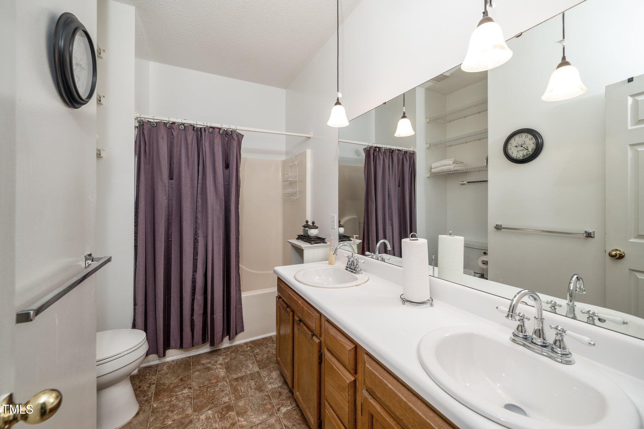6008 River Lake Circle Raleigh, NC 27604 - Photo 13 of 25 a bathroom with a double vanity sink toilet and a mirror