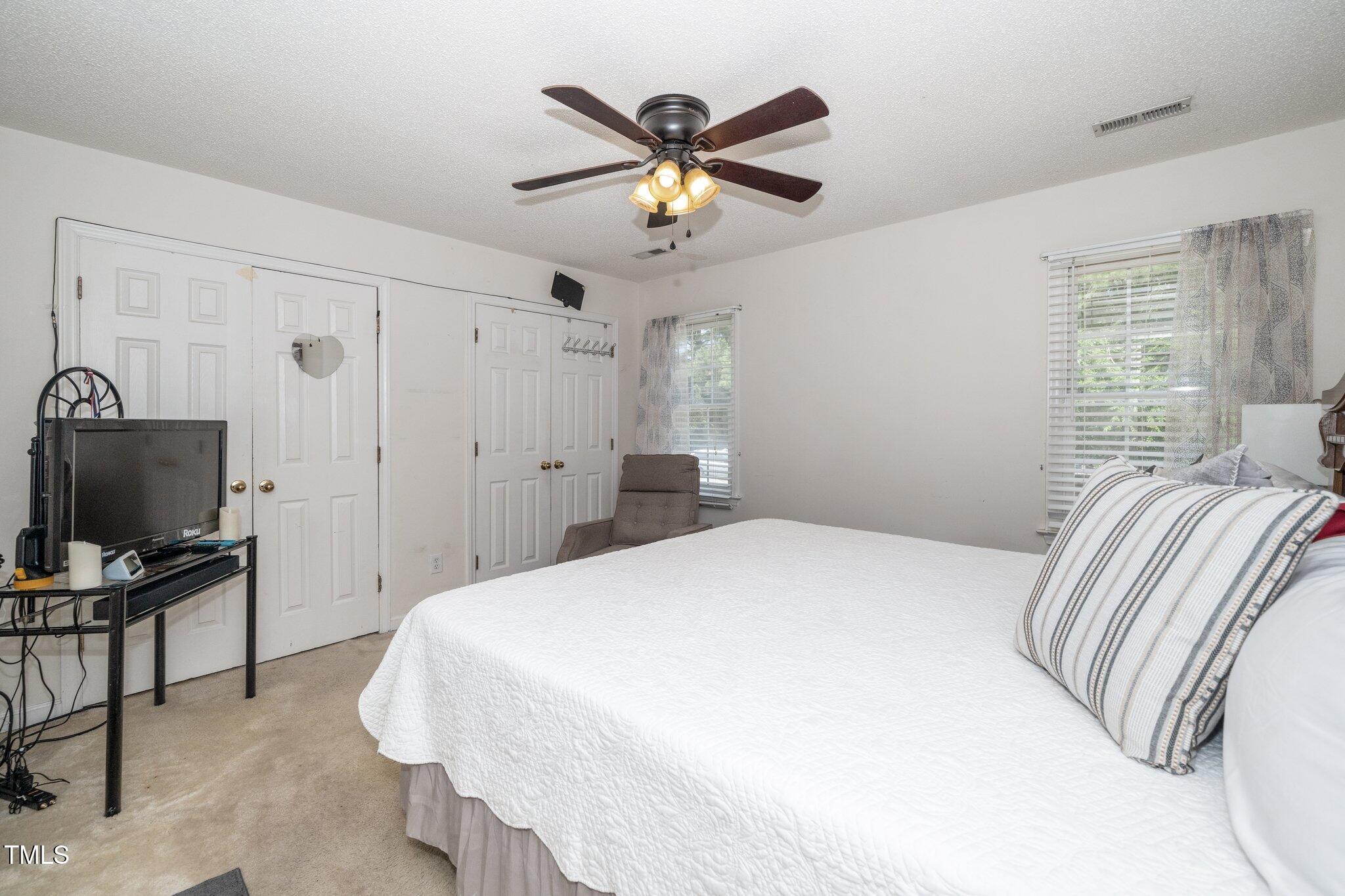 6008 River Lake Circle Raleigh, NC 27604 - Photo 14 of 25 a bedroom with a bed and ceiling fan