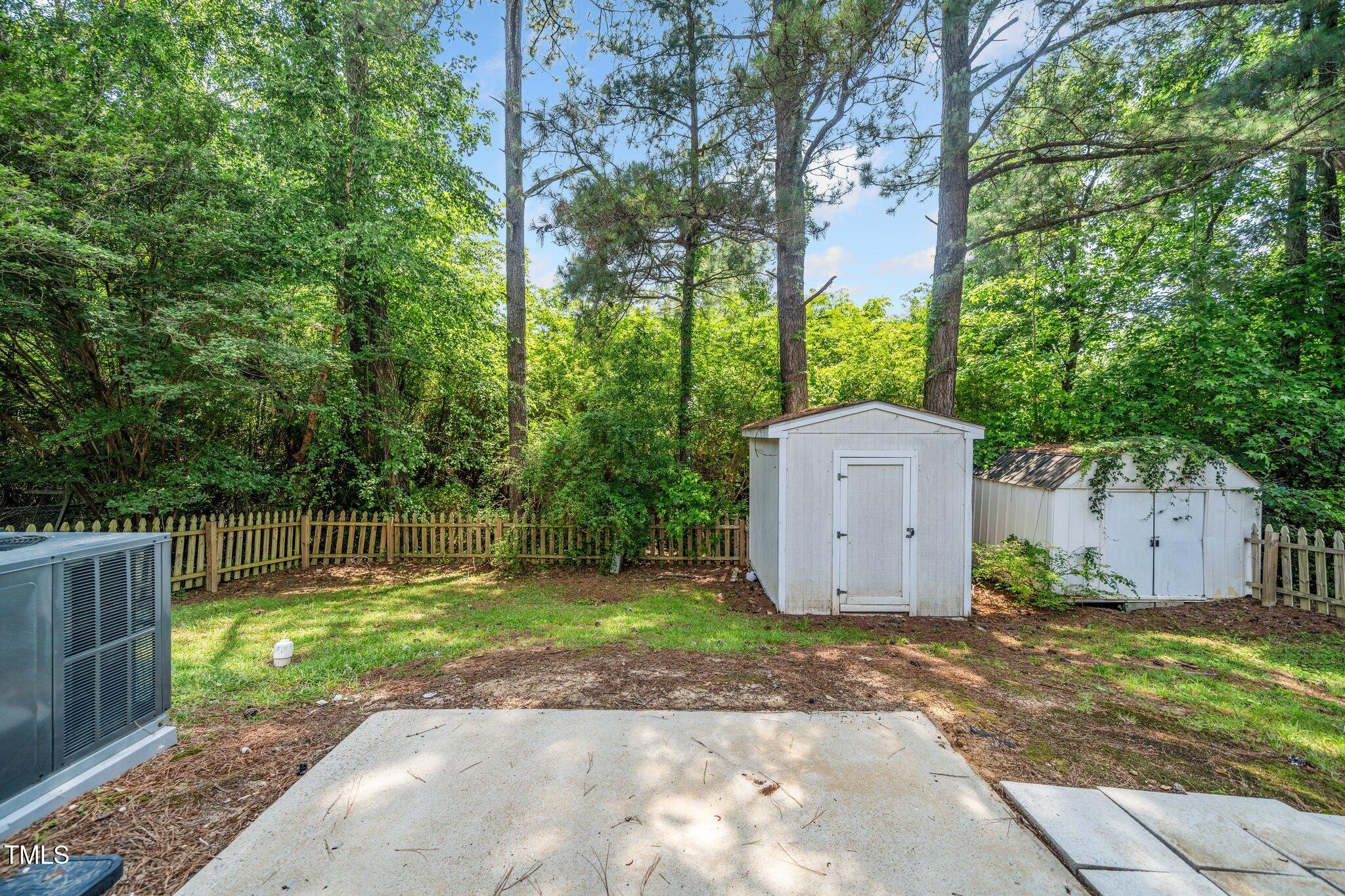 6008 River Lake Circle Raleigh, NC 27604 - Photo 20 of 25 a backyard of a house with large trees and wooden fence