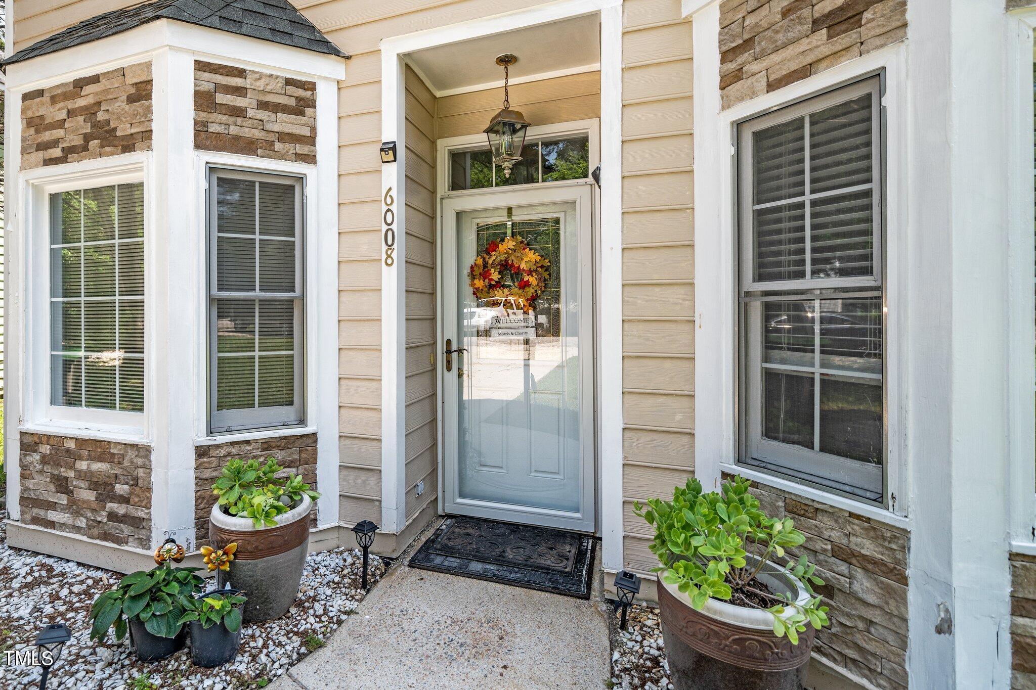 6008 River Lake Circle Raleigh, NC 27604 - Photo 2 of 25 a front view of a house with a potted plant and a window