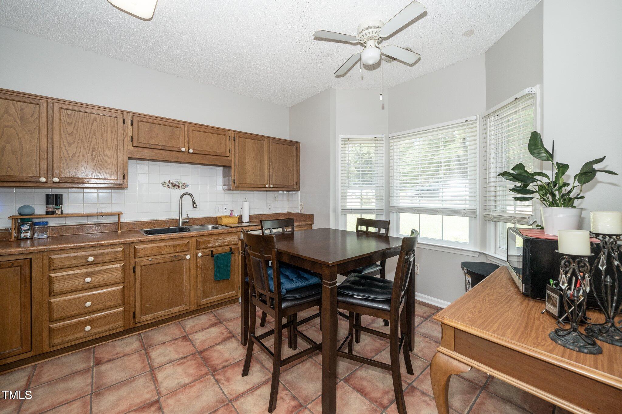 6008 River Lake Circle Raleigh, NC 27604 - Photo 3 of 25 a kitchen with a table chairs and white cabinets