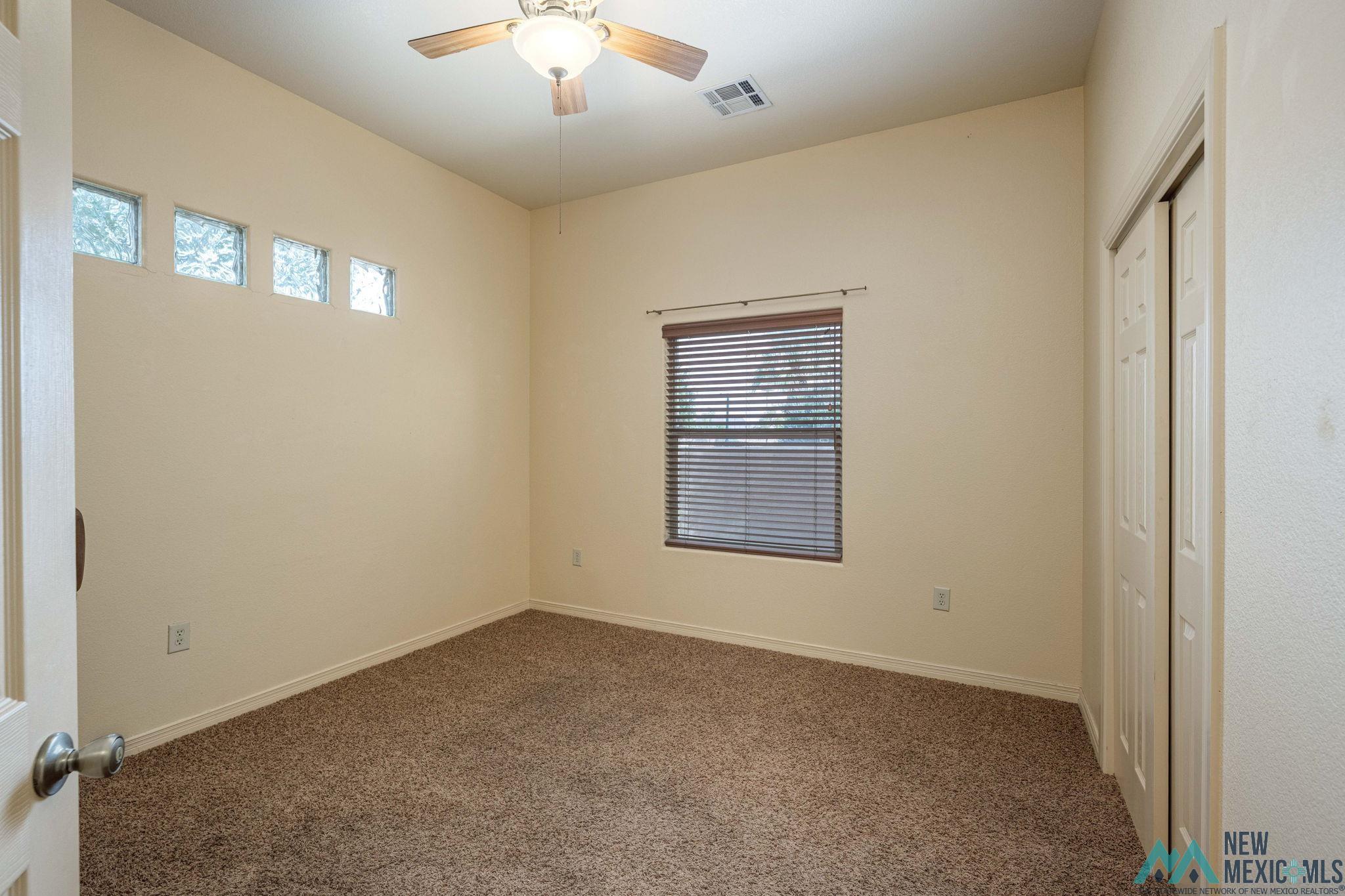 3884 Adriatic Road Las Cruces, NM 88012 - Photo 30 of 45 Carpeted interior space featuring a ceiling fan with integrated lighting, a window with horizontal blinds, and a bi-fold closet door