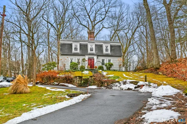 a view of a house with snow on the side of the road