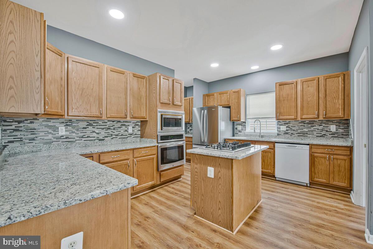 1329 Canberra Drive Baltimore, MD 21221 - Photo 11 of 43 a kitchen with stainless steel appliances granite countertop a stove a sink and a microwave