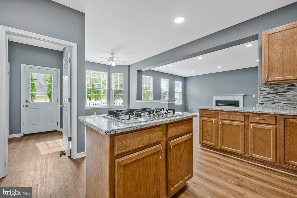1329 Canberra Drive Baltimore, MD 21221 - Photo 16 of 43 a kitchen with cabinets wooden floor and a stove top oven