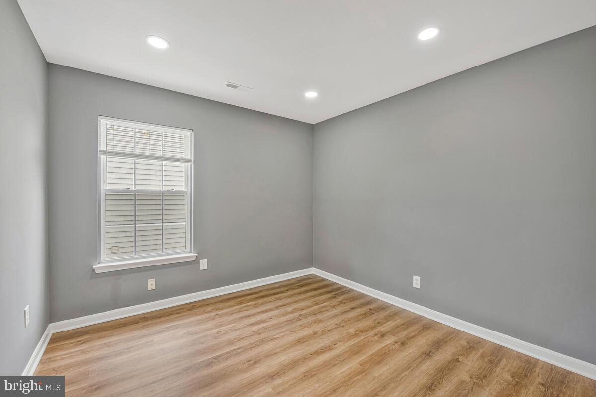 1329 Canberra Drive Baltimore, MD 21221 - Photo 23 of 43 a view of empty room with wooden floor and fan