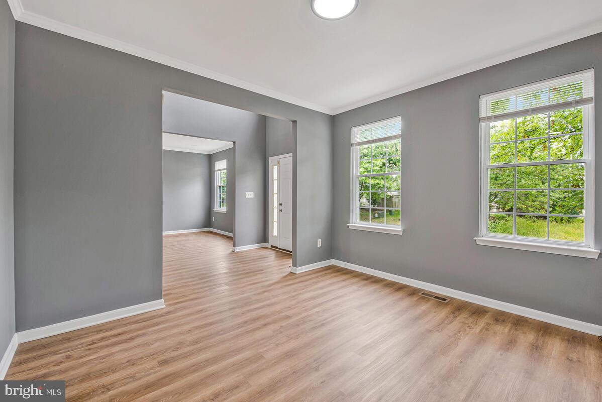 1329 Canberra Drive Baltimore, MD 21221 - Photo 7 of 43 a view of an empty room with wooden floor and a window