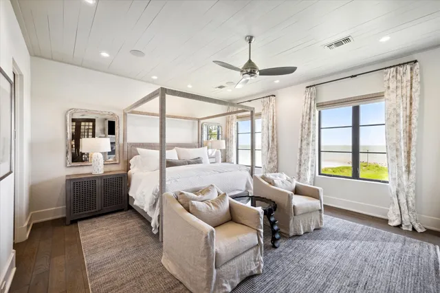 a bedroom with a large bed couch and a flat tv screen