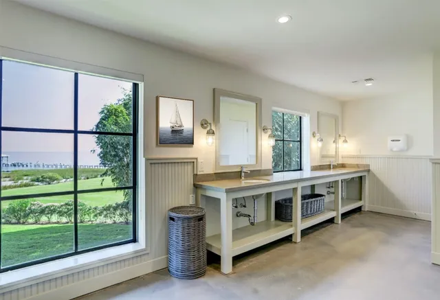 a large white kitchen with stainless steel appliances granite countertop a refrigerator and a sink