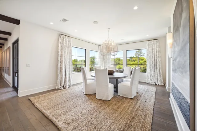 a kitchen with stainless steel appliances kitchen island granite countertop a table chairs in it and wooden floors