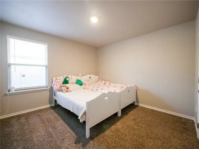 a white bed sitting in a bedroom next to a window