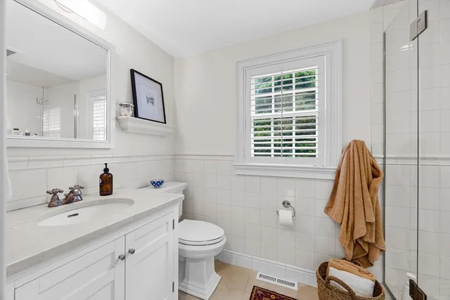 a bathroom with a sink a toilet and a window