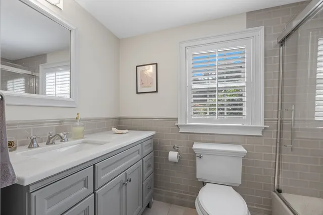 a bathroom with a granite countertop toilet sink and mirror