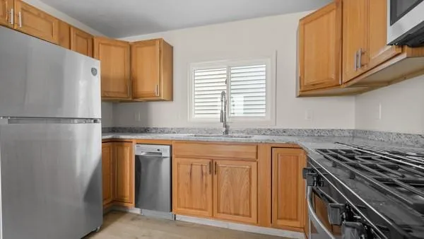 a kitchen with granite countertop a refrigerator and a sink