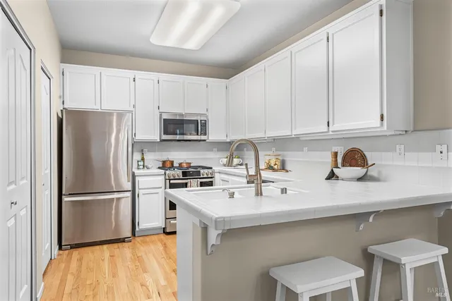 a kitchen with cabinets stainless steel appliances and a sink