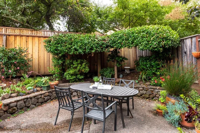 a view of a patio with table and chairs under an umbrella