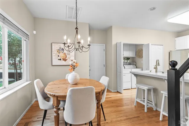 a dining room with furniture a chandelier and wooden floor