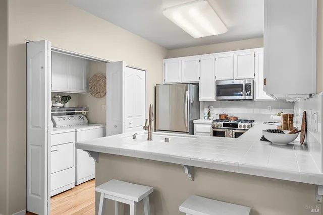 a kitchen with appliances a sink and cabinets