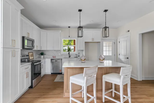 a kitchen with appliances cabinets and chair