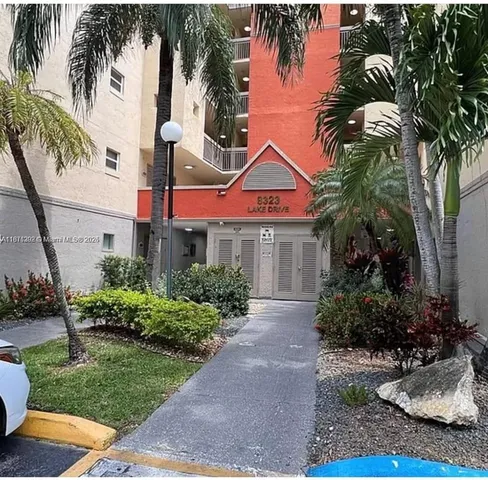 a front view of a house with a yard and potted plants
