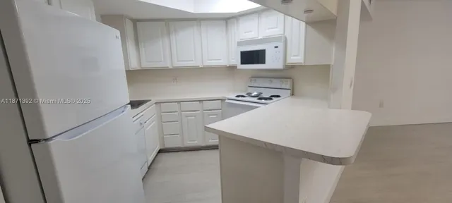 a kitchen with appliances a sink and cabinets