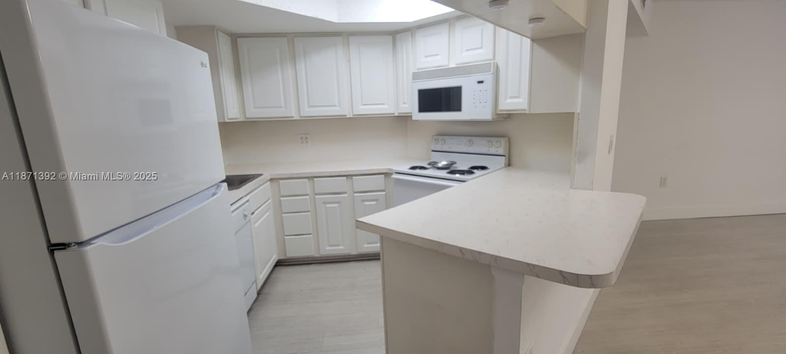 8323 Lake Drive, Unit 404 Doral, FL 33166 - Photo 3 of 11 a kitchen with appliances a sink and cabinets