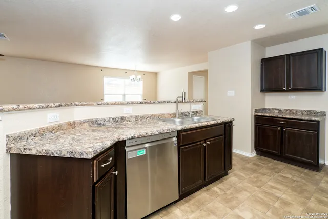a kitchen with granite countertop a sink and a stove top oven