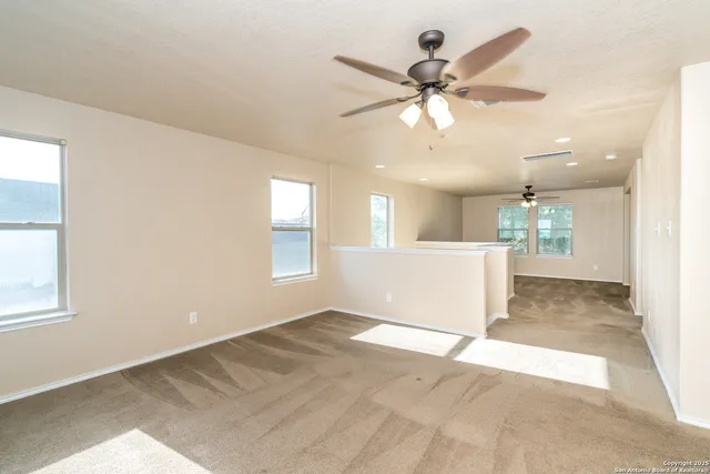 an empty room with fan and windows