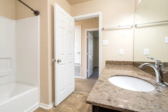 a bathroom with a granite countertop sink and a mirror