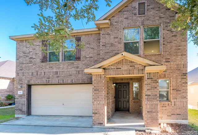 a view of a brick house with large windows