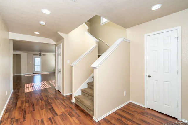 a view of a hallway with wooden floor and staircase