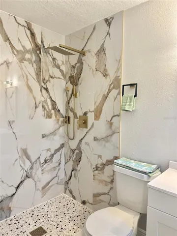 a bathroom with a sink a toilet and shower